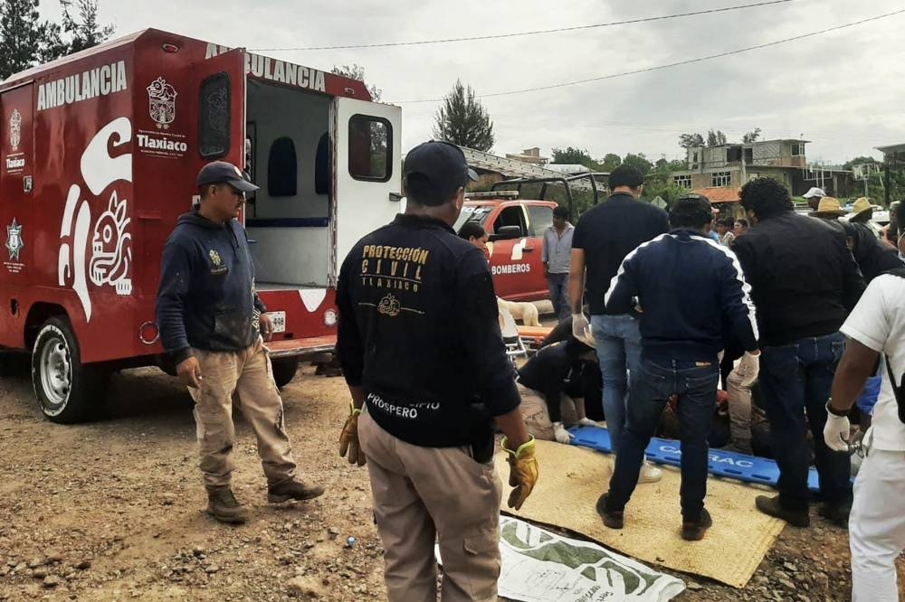 Municipal workers and members of the municipal police working at the site where a bus plummeted into a ravine in the outskirts of Magdalena Peñasco, Oaxaca state, Mexico.  AFP/ TLAXIACO MUNICIPAL POLICE