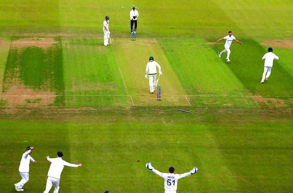 England's Mark Wood celebrates after taking the wicket of Australia's Usman Khawaja on day one of the third Ashes Test at Headingley, Leeds, on Thursday. (Reuters)
