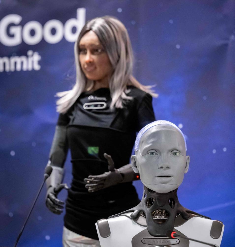 Humanoid AI robot "Ameca" (R) and CEO female robot "Mika" (L) are showcased in what was presented as the World's first press conference with a panel of AI-enabled humanoid social robots as part of International Telecommunication Union (ITU) AI for Good Global Summit in Geneva, on July 7, 2023. The United Nations is convening this week a global gathering to try to map out the frontiers of artificial intelligence and to harness its potential for empowering humanity, hoping to lay out a clear blueprint on the way forward for handling AI, as development of the technology races ahead the capacity to set its boundaries. (Photo by Fabrice COFFRINI / AFP)