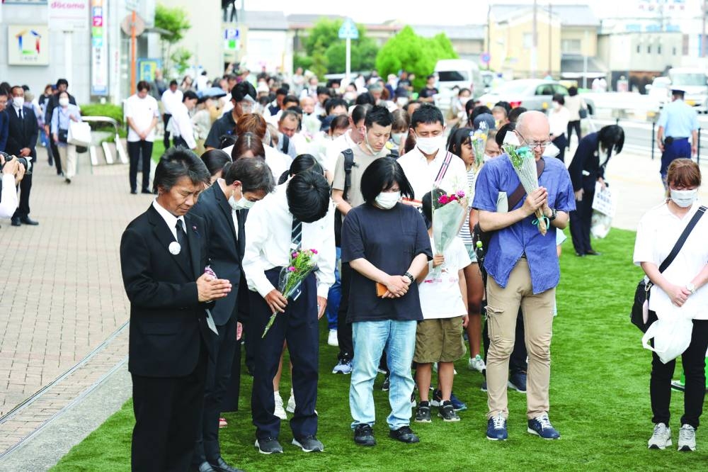 People pray outside Yamato-Saidaiji Station, where former Japanese prime minister Shinzo Abe was shot one year ago, during a memorial service on his first death anniversary in Nara city, yesterday.