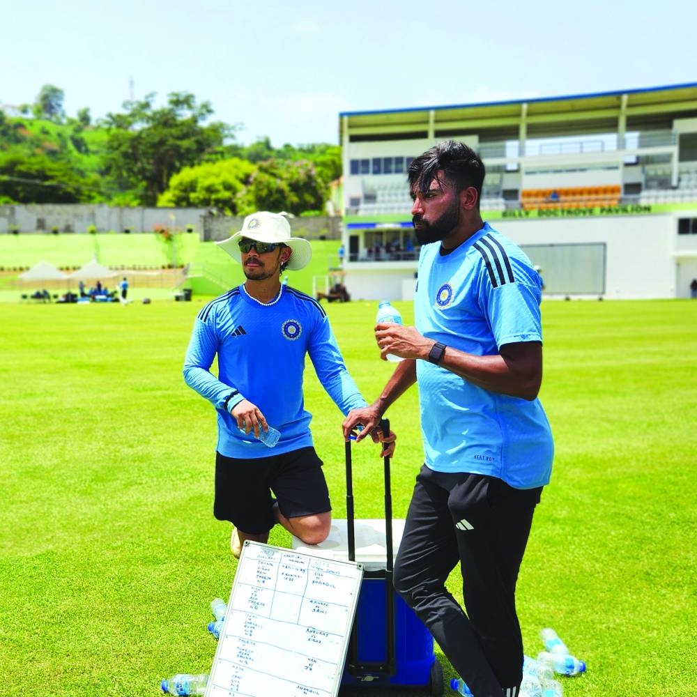 
India’s players huddle up prior to a team training session at Windsor Park Stadium in Dominica. Right: India’s Mohamed Siraj (right) and Ishan Kishan during a team training session in Dominica. 