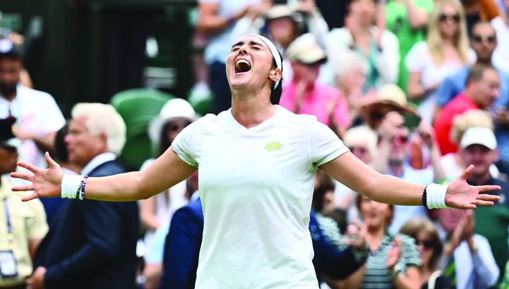 Tunisia’s Ons Jabeur celebrates beating Kazakhstan’s Elena Rybakina during their quarter-finals at Wimbledon on Wednesday. (AFP)