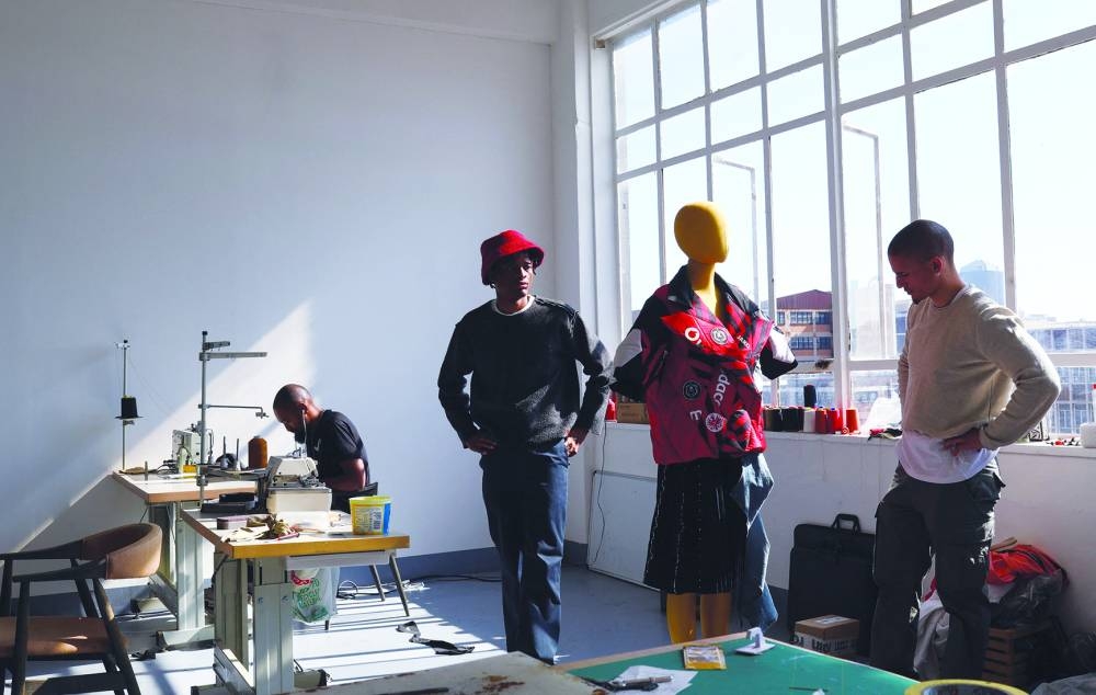 
South African aspiring designers Khumo Morojele and Klein Muis look at one of their designs made from second-hand clothing imported from the West. 