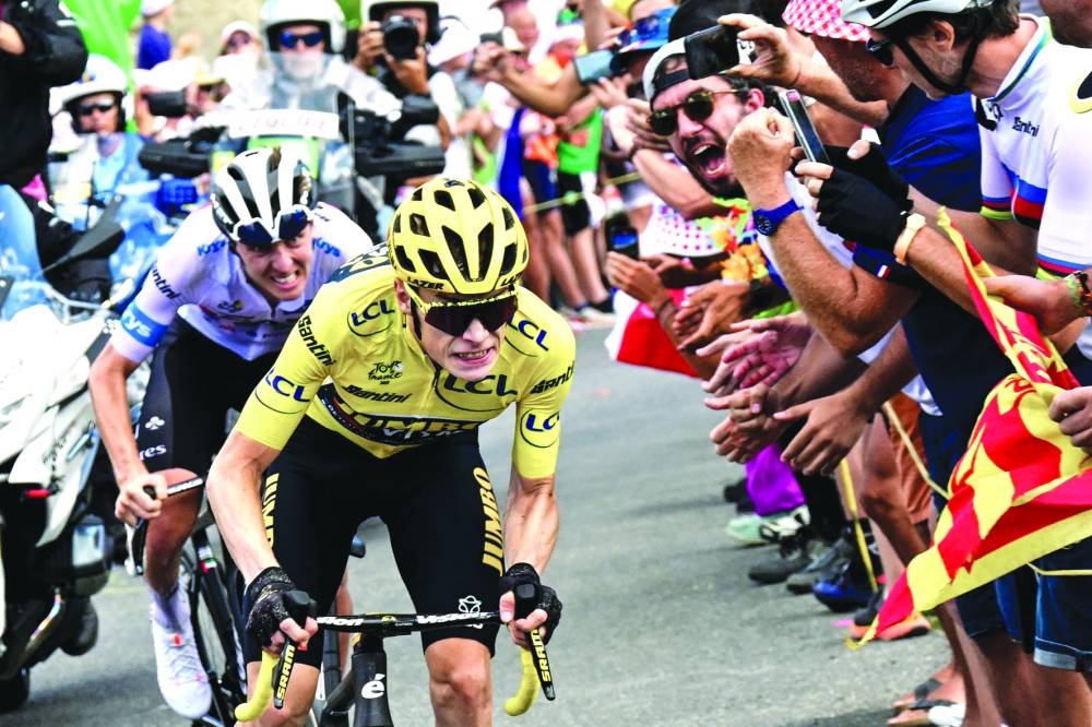 Jumbo-Visma’s Danish rider Jonas Vingegaard - wearing the overall leader’s yellow jersey - cycles ahead of UAE Team Emirates’ Slovenian rider Tadej Pogacar - sporting the best young rider’s white jersey - in the final ascent during the 14th stage of the 110th edition of the Tour de France on Saturday. (AFP)