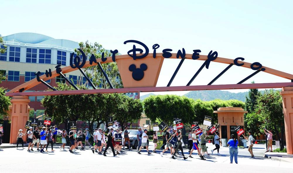 Members of the Writers Guild of America and the Screen Actors Guild walk a picket line outside Disney Studios in Burbank, California.
