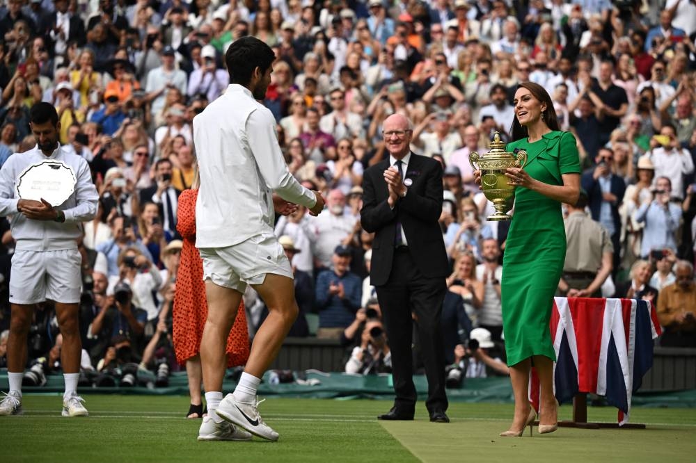 Spain's Carlos Alcaraz receives the trophy from Britain's Catherine, Princess of Wales after winning his final match against Serbia's Novak Djokovic. REUTERS/Dylan Martinez
