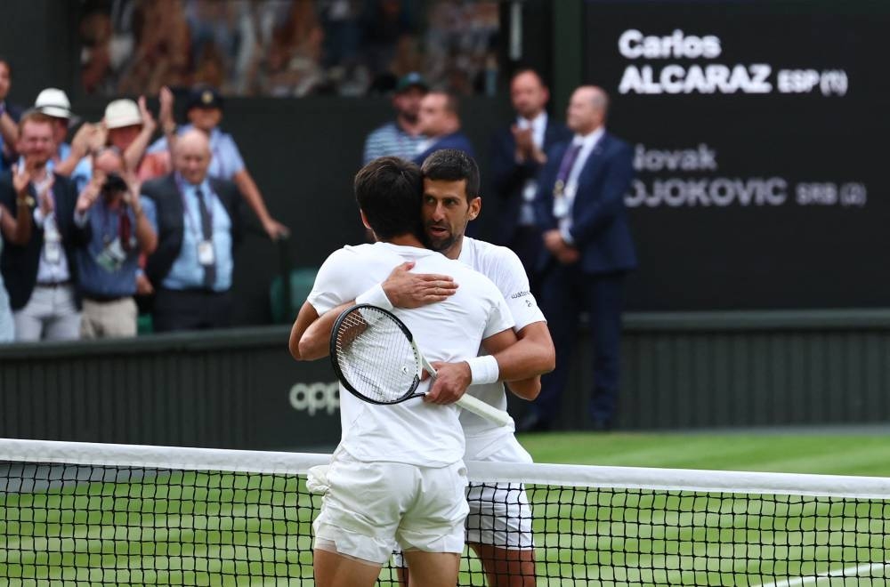 Spain's Carlos Alcaraz with Serbia's Novak Djokovic after winning the final. REUTERS/Toby Melville