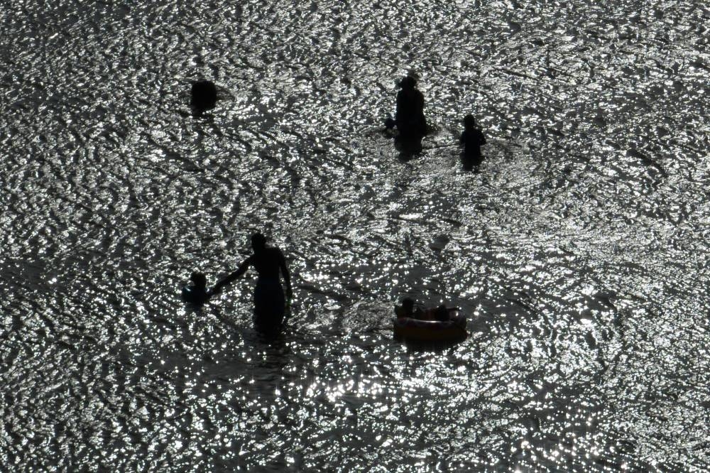 Residents take a dip in Galveston Bay during hot weather in Texas City, Texas, US, July 15.  REUTERS/Adrees Latif