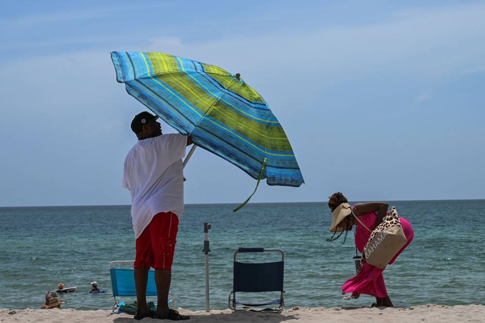 Beachgoers enjoy sunbathing during during an intense heat wave in Miami Beach on July 16. GIORGIO VIERA / AFP