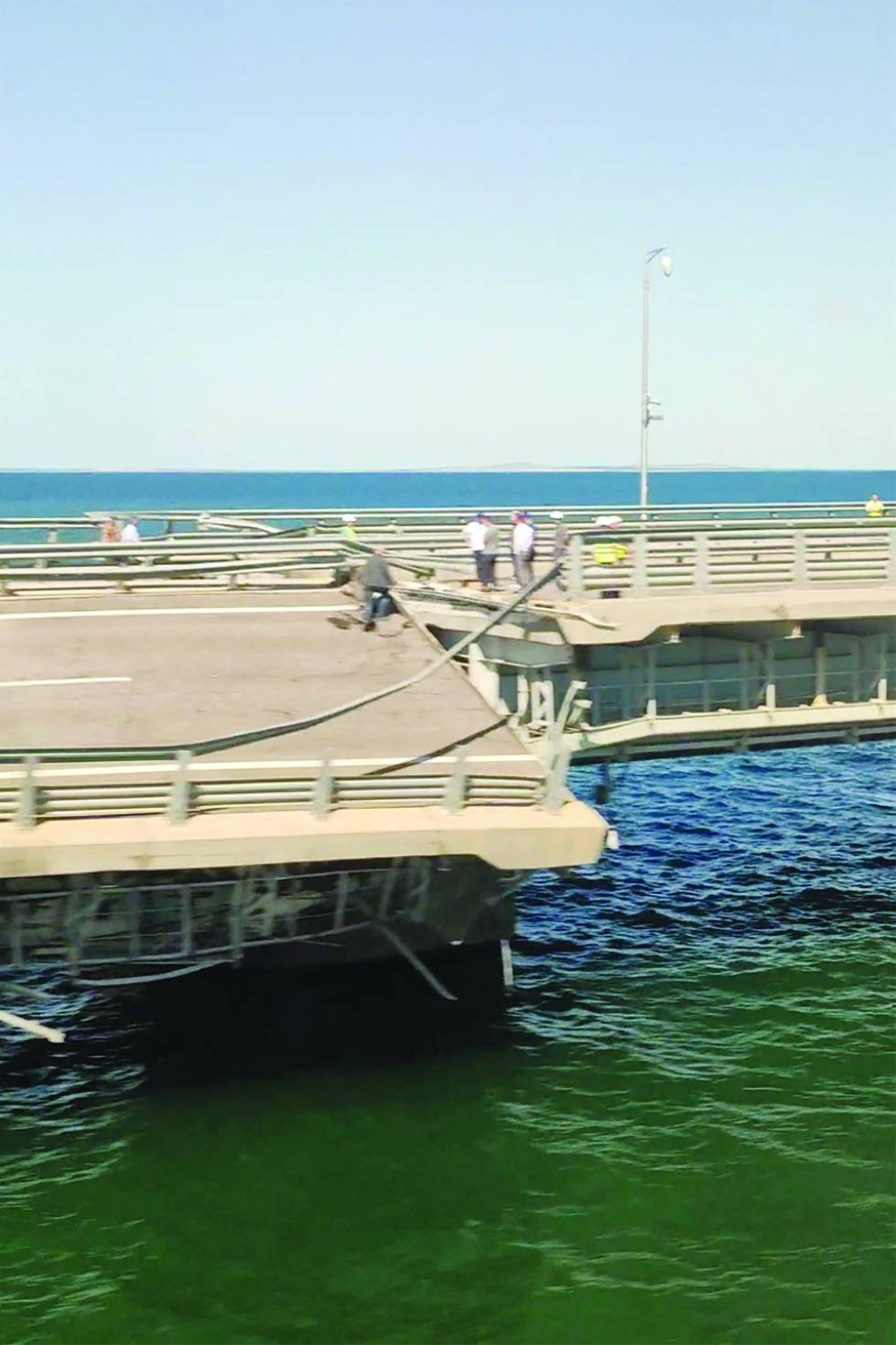 
A view through a train window shows the section of a road split and sloping to one side following an alleged attack on the Crimea Bridge, that connects the Russian mainland with the Crimean peninsula across the Kerch Strait, in this still image from video taken yesterday. 