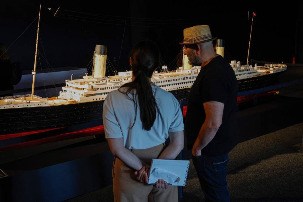 Visitors look at the replicated model of the HMS Titanic liner, on the opening day of the XXL Titanic exhibition at Paris Expo Porte de Versailles in Paris. AFP