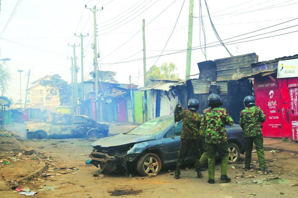 
Police officers take cover as supporters of Kenya’s opposition leader Raila Odinga stage a protest in Nairobi. 