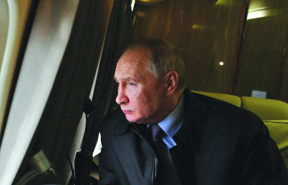 
Russian President Vladimir Putin looks through a helicopter window during his flight to the Novatek-Murmansk’s Offshore Superfacility Construction Center in the village of Belokamenka in Murmansk region on Thursday. (Reuters) 