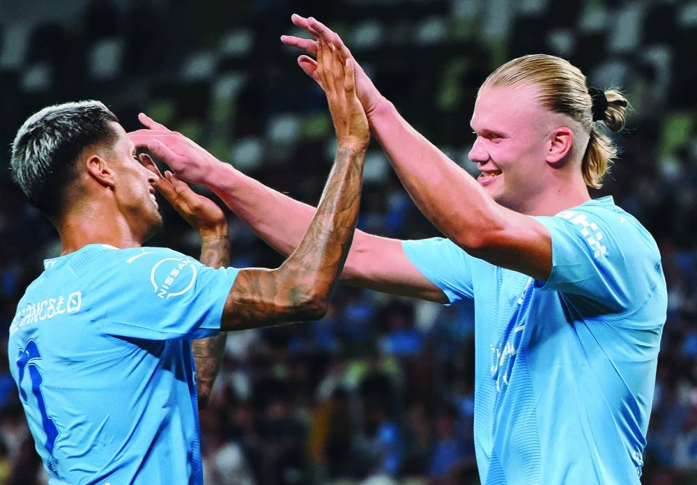 Manchester City’s Erling Haaland (right) celebrates with Joao Cancelo after scoring a goal during the J-League World Challenge 2023 match against Yokohama F-Marinos in Tokyo on Sunday. (AFP)