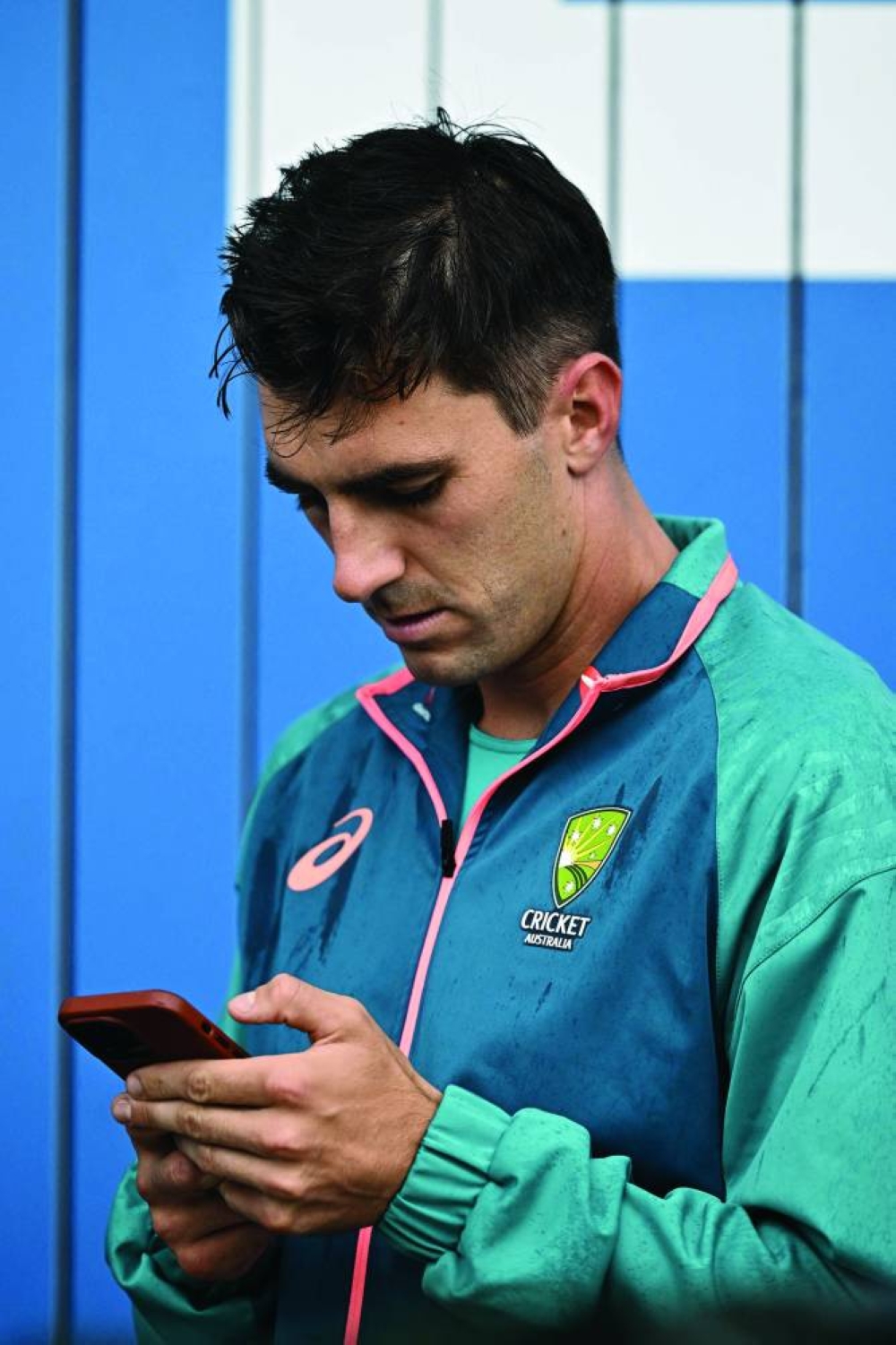 Australia’s Pat Cummins checks his phone after the match is abandoned without any play on day five of the fourth Ashes Test against England at Old Trafford in Manchester on Sunday. (AFP)