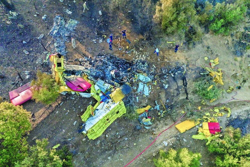 Rescuers operate at the site where a firefighting plane crashed after a water drop as a wildfire burns in Platanistos on the island of Evia on Tuesday.  (Reuters)
