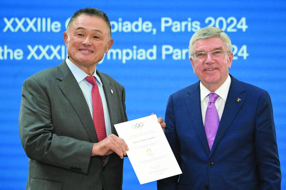 
The President of the International Olympic Committee Thomas Bach (right) and the representative of the National Olympic Committee of Japan Yasuhiro Yamashita pose during a ceremony to mark one year until the start of Paris Olympics in Saint-Denis, outside Paris. (AFP)  