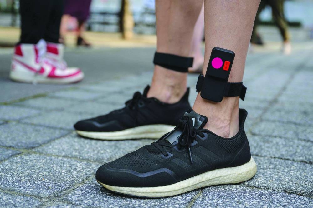 A concertgoer wears a vibrating ankle bracelet, part of a haptic suit, created for the deaf by Music: Not Impossible, during an outdoor concert.