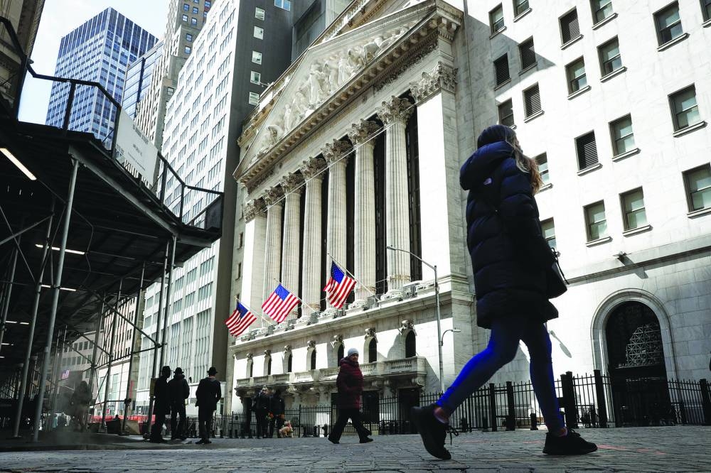 
People are seen on Wall Street outside the New York Stock Exchange. Investors on Wall Street and beyond are betting that the great tech rally of 2023 has staying power, even as they appear sceptical that the AI era will live up to the hype. 