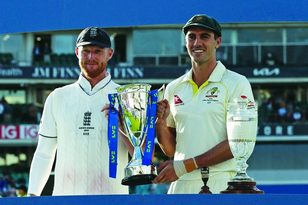 England's captain Ben Stokes (left) and Australia's captain Pat Cummins hold the series trophy after the drawn Ashes Series at The Oval in London yesterday. (Reuters)