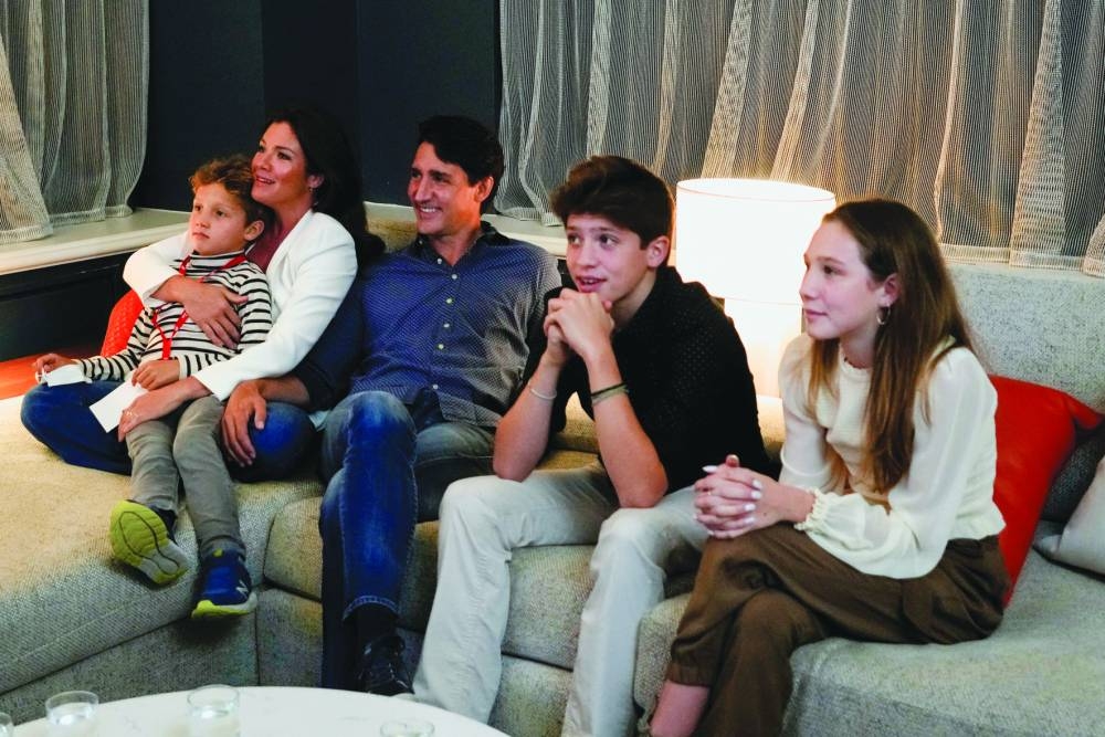 Trudeau, accompanied by Sophie and their children Ella-Grace, Xavier and Hadrien, watch the election coverage on a TV, in Montreal, Quebec, on September 20, 2021. (Reuters)