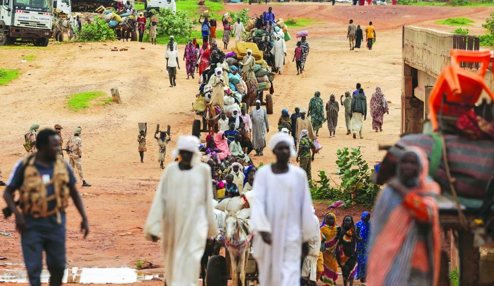 Sudanese people, who fled the conflict in Murnei in Sudan’s Darfur region, cross the border between Sudan and Chad in Adre.