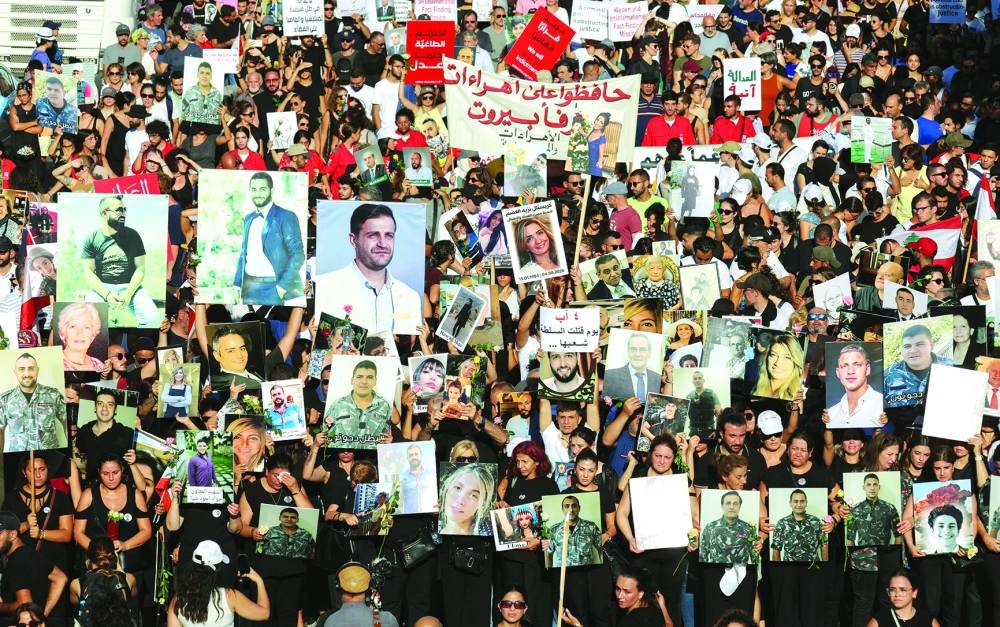 People and families of the victims of port blast, carry their pictures during a march as Lebanon marks the three-year anniversary of the explosion in Beirut.