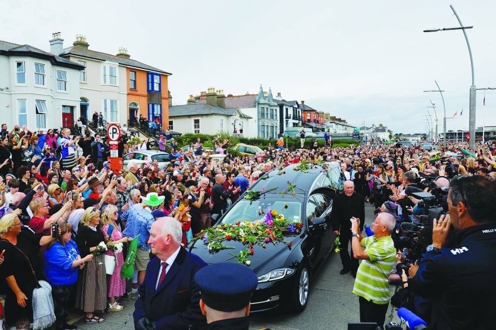 A hearse carrying the coffin of late Irish singer Sinead O’Connor passes by during her funeral procession as fans line the street to say their last goodbye to her, in Bray, Ireland, on Tuesday.