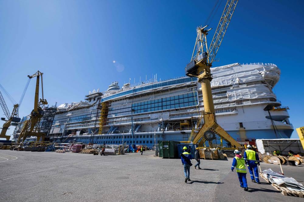 Workers walk at the construction site of the Royal Caribbean's new ship 'Icon of the Seas' at the Turku shipyard in Finland's southwest coast on May 30, 2023. AFP