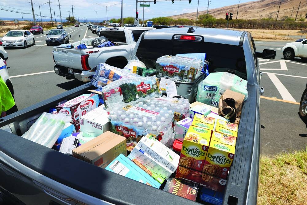 
Right: A truck carrying supplies for people affected by the West Maui wildfires gets stuck in heavy traffic after officials allowed residents and tourists back into the area. 
