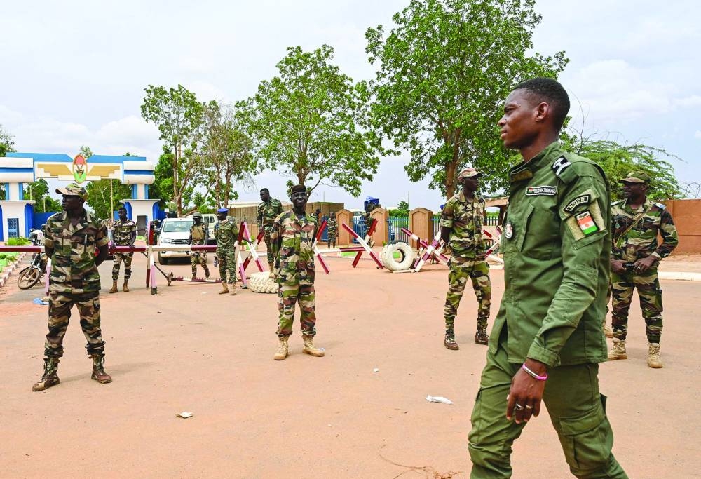 Nigerien soldiers stand guard as supporters of Niger’s National Council for the Safeguard of the Homeland (CNSP) gather for a demonstration in Niamey. (AFP)