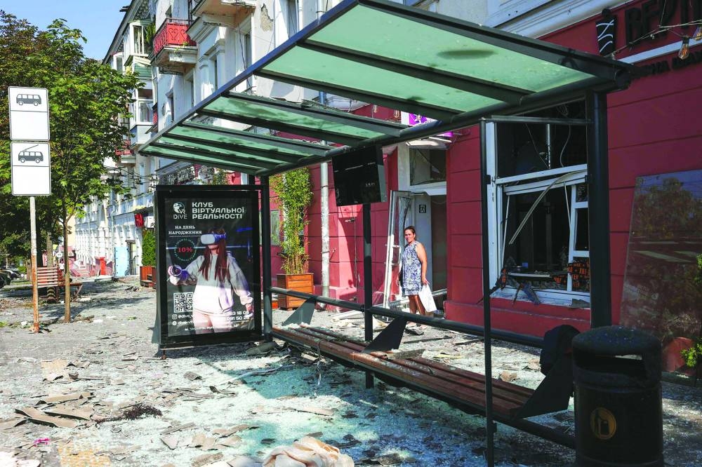 A local resident stands amid the debris and shattered glass of windows following a missile strike in Chernihiv, on August 19, 2023. (Photo by Anatolii STEPANOV / AFP)