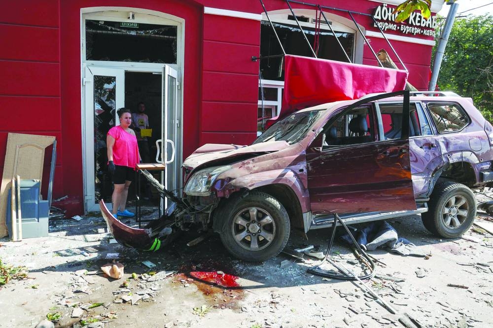 TOPSHOT - A local resident stands next to a damaged car at the site of a missile strike in Chernihiv, on August 19, 2023. A Russian missile strike on Ukraine's northern city of Chernihiv killed at least five people and wounded dozens. (Photo by Anatolii STEPANOV / AFP)