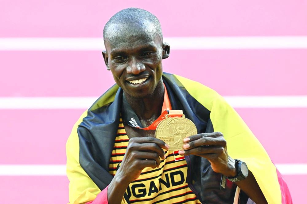 Uganda’s 10,000m gold medallist Joshua Cheptegei celebrates while draped in a national flag on Sunday. (AFP)