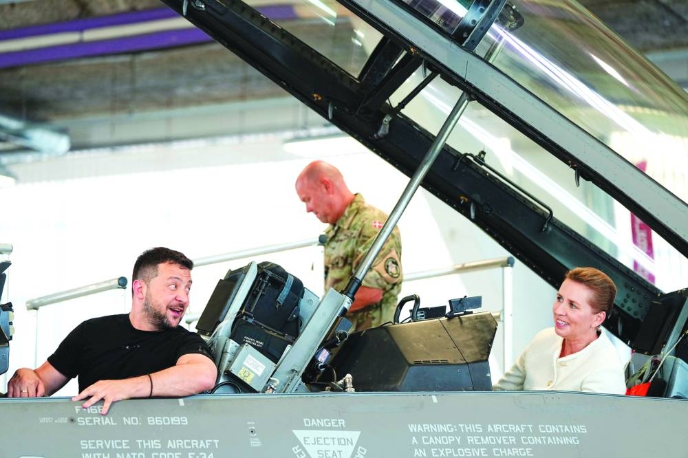 
Ukrainian President Volodymyr Zelensky (left) and Danish Prime Minister Mette Frederiksen react as they sit in a F-16 fighter jet in the hangar of the Skrydstrup Airbase in Vojens, northern Denmark, yesterday. (AFP) 
