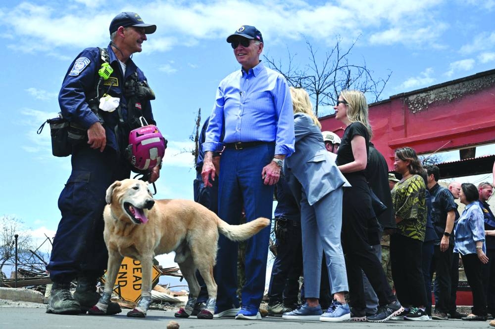 
Biden is seen with a rescue dog wearing protective boots during a meeting with first responders during an operational briefing on response and recovery efforts in Lahaina. 