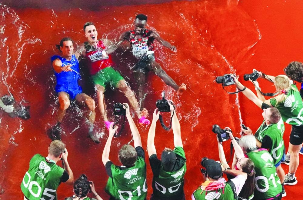 High jump champion Gianmarco Tamberi (left), men’s 3000m steeplechase gold medallist Soufiane El Bakkali (centre) and bronze medallist Kenya’s Abraham Kibiwot celebrate by jumping into the water in Budapest on Tuesday. (Reuters)