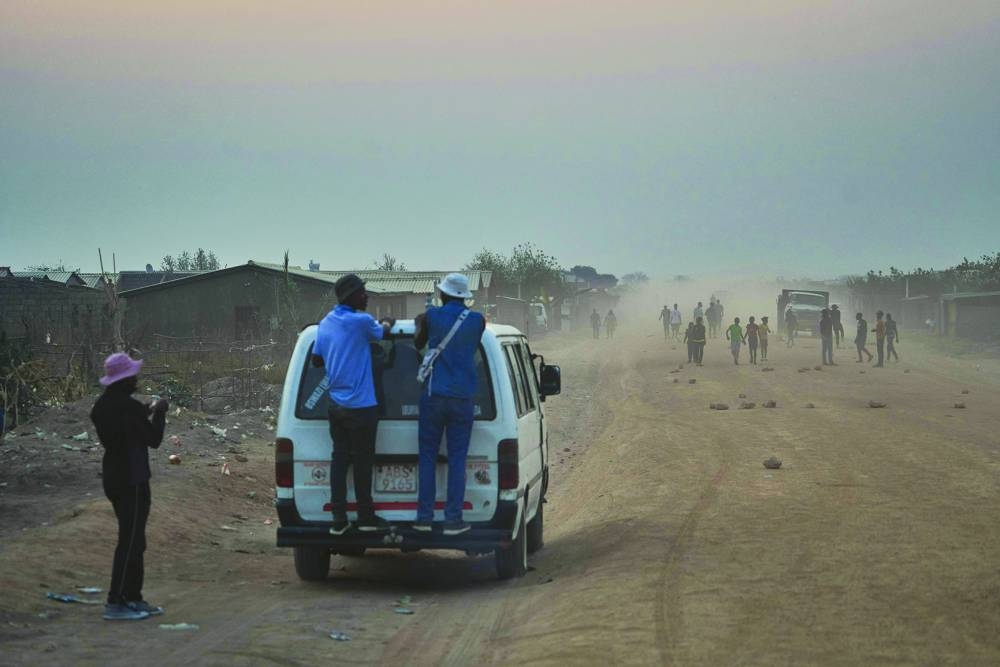 
People board a van at dusk near a polling station in Harare. 