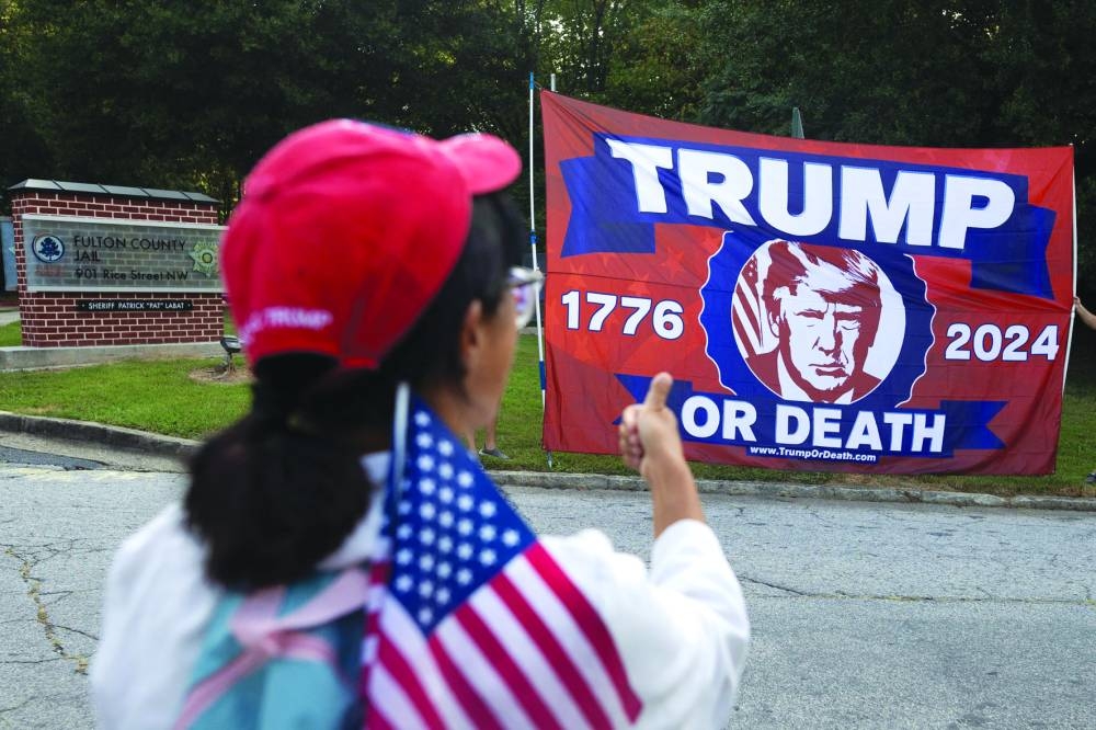 
A Trump supporter waves flag outside the Fulton County Jail. 