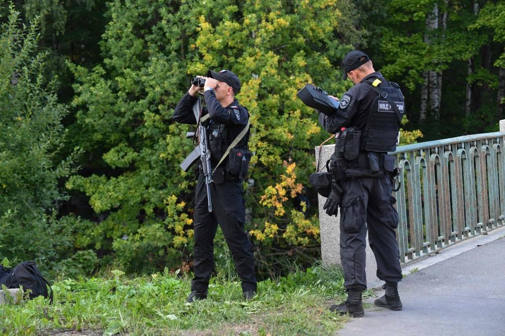 Police officers watch an area near the Porokhovskoye cemetery where Wagner private mercenary group chief Yevgeny Prigozhin, who was killed in a private jet crash in the Tver region last week, was buried, in Saint Petersburg. AFP