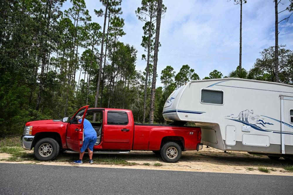 A man loads his motor home at the back of a car in Steinhatchee, Florida as preparations are made ahead of Hurricane Idalia. AFP