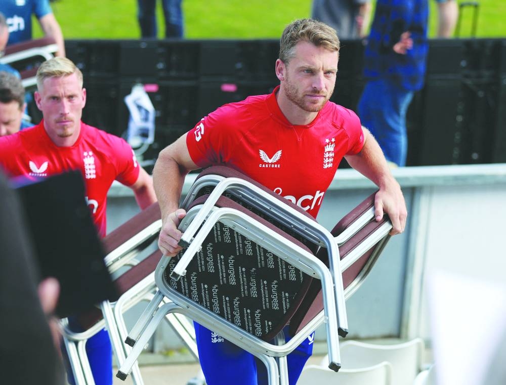 England’s Jos Buttler holds chairs after a team group photo at Riverside Ground, Chester-le-Street, Britain, on Tuesday. (Reuters)