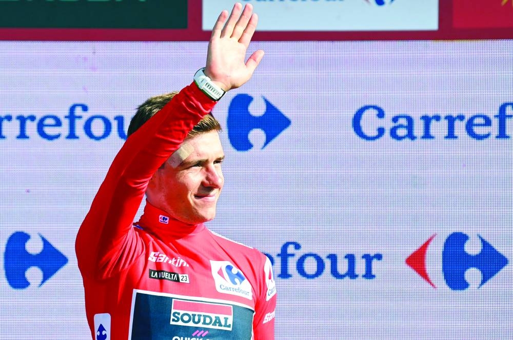 Team Quick Step’s Belgian rider Remco Evenepoel celebrates on the podium after retaining the overall leader’s red jersey 
on Wednesday. (AFP)