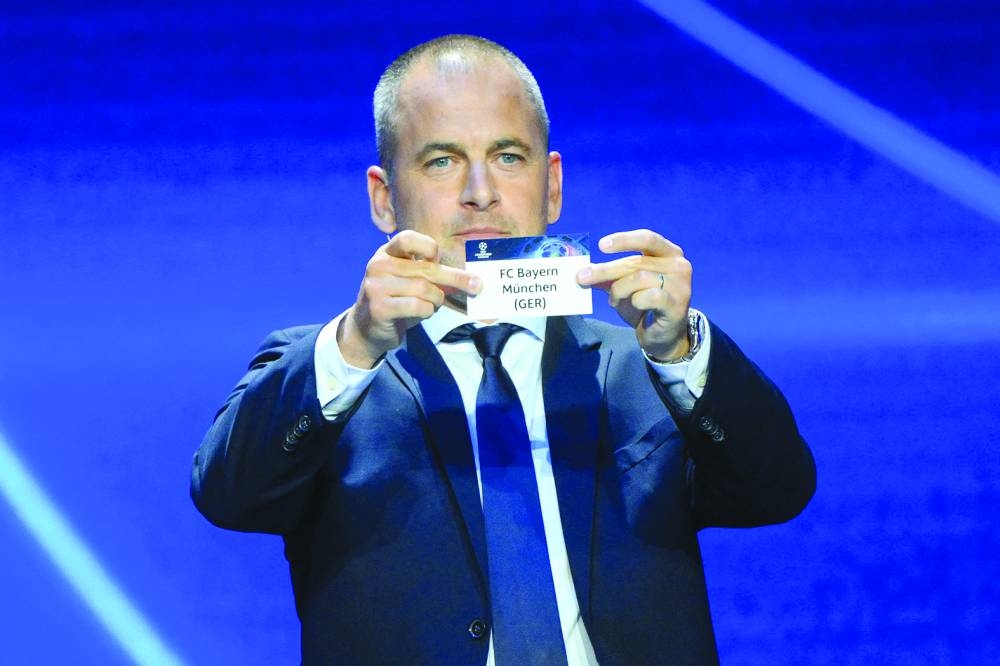 Former England and Chelsea footballer Joe Cole shows the paper slip of FC Bayern Munich during UEFA Champions League group stage draw in Monaco on Thursday. (AFP)