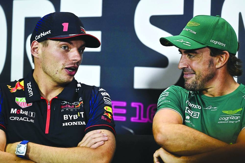 Aston Martin’s driver Fernando Alonso (right) chats with Red Bull Racing’s driver Max Verstappen as they take part in a press conference ahead of the Singapore Formula One Grand Prix night at the Marina Bay Street Circuit in Singapore on Thursday. (AFP)