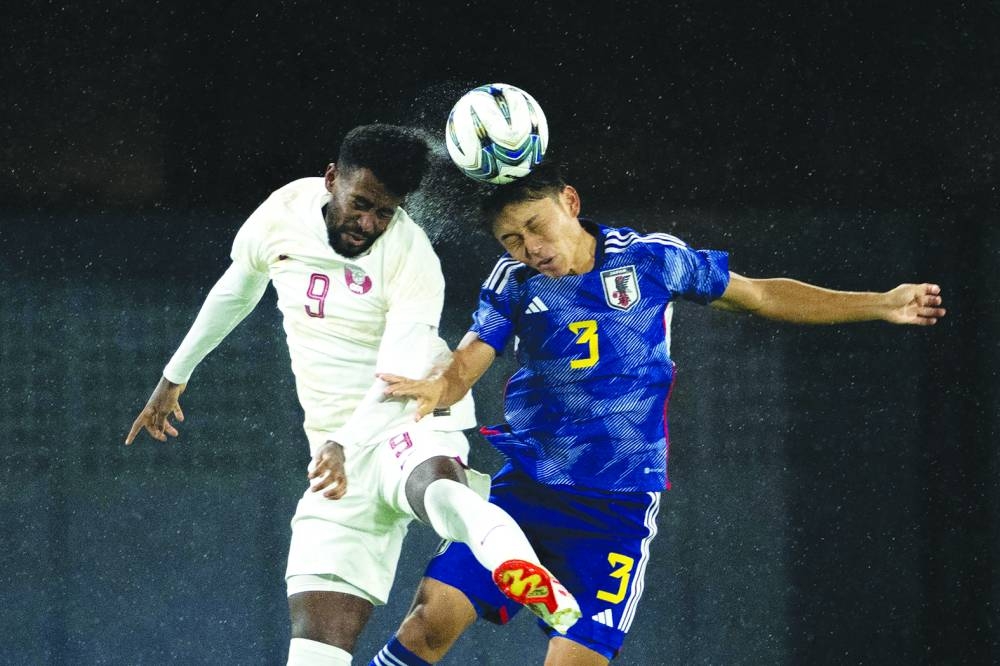 Japan’s Manato Yoshida (right) and Qatar’s Tameem al-Abdullah jump to head the ball during the Hangzhou 2022 Asian Games football match at the Xiaoshan Sports Centre Stadium in Hangzhou on Wednesday. (AFP)
