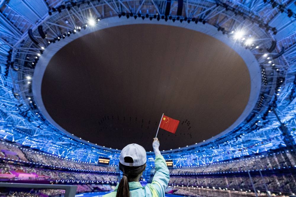 A person holds a Chinese flag during the Opening Ceremony. REUTERS.