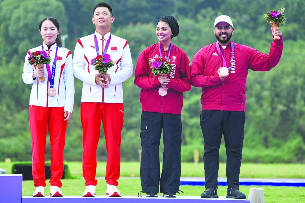 Qatar’s skeet mixed team pair Reem al-Sharshani (left) and Rashid Saleh al-Athba celebrate after winning the bronze medal in Hangzhou on Thursday.