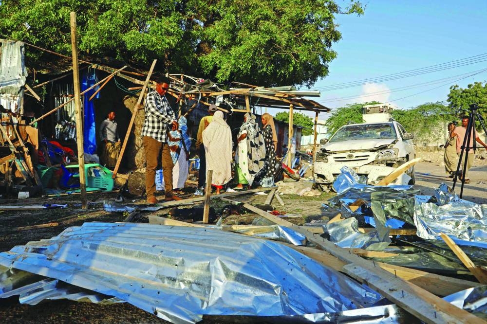 
Wreckages of vehicles are seen at scene of an explosion claimed to be set off by a suspected member of Al Qaeda-linked Al Shebaab, at a shop selling tea near a security checkpoint on a road leading to the parliament and the president’s office in Mogadishu, yesterday. 