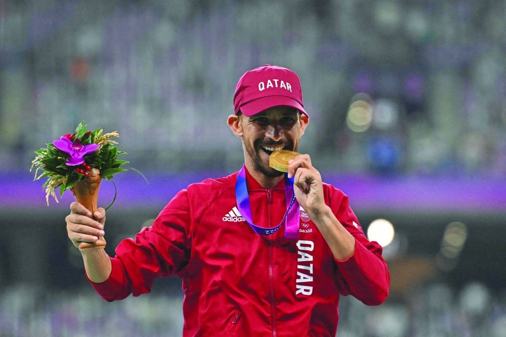 Gold medallist Qatar’s Mohamed al-Garni celebrates on the podium during the medal ceremony for the men’s 1,500m race on Sunday. (AFP)